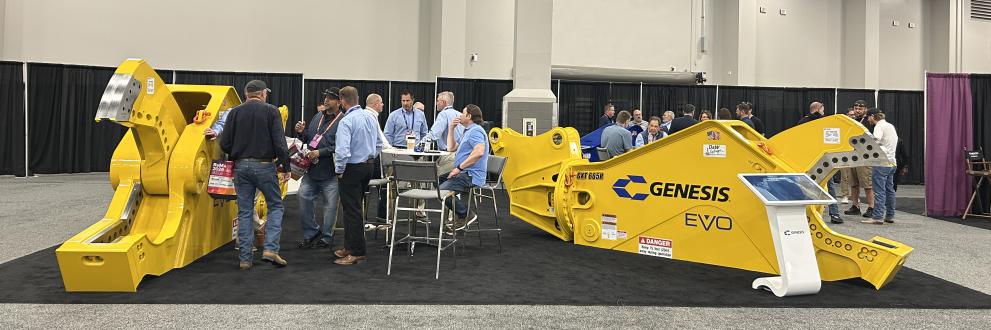 Yellow mobile shears and people in a Genesis trade show booth.